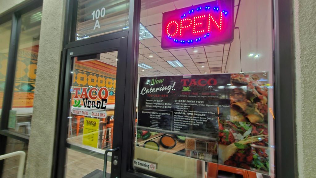 aco Verde restaurant's entrance with interior view and catering menu visible.